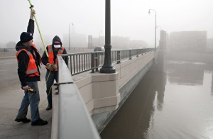 Checking the water level on a bridge between Fargo and Moorhead. Photo from Minnesota Public Radio.