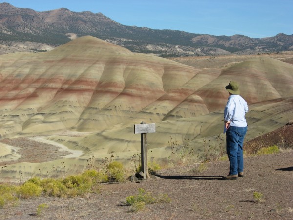 Red and white striped badlands. Person in foreground at right.